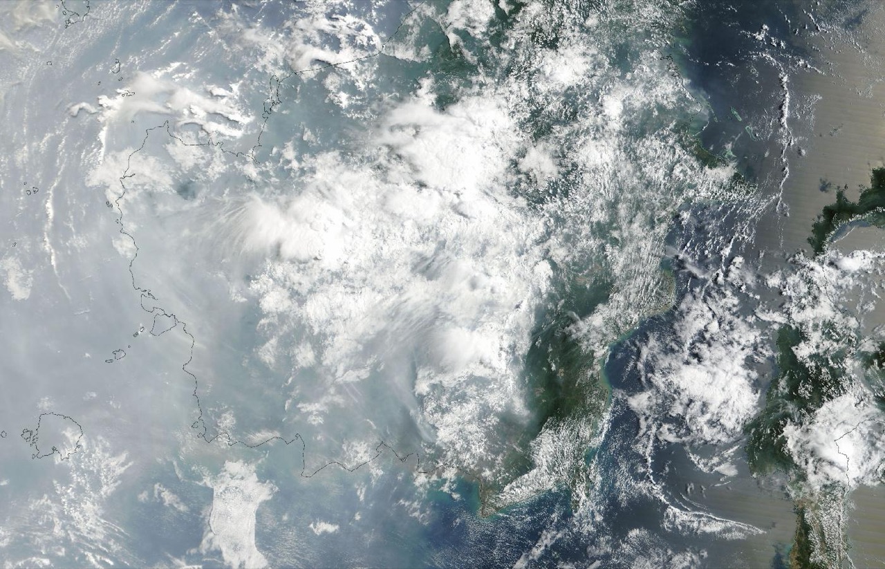 Satellite image of grey smoke haze and scattered cloud over the west coast of Borneo and the sea beside it.